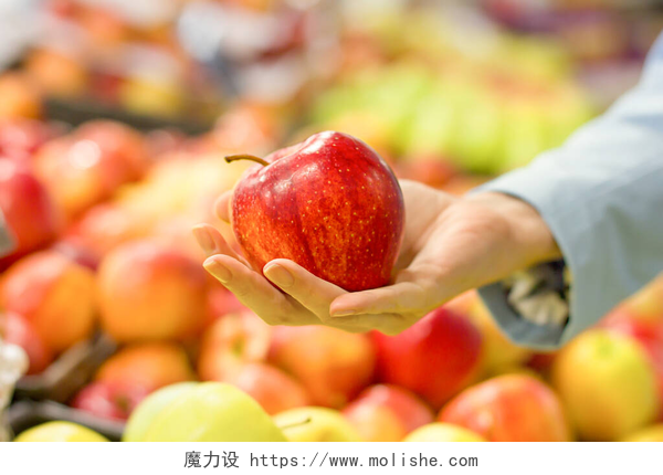 超市水果区域挑选苹果的手部特写女人的手在超市选苹果.有意识地选择生物、素食、饮食和健康食品的概念